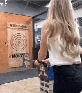 A Woman Is Throwing An Axe At A Target That Says #Bad Axe GIF