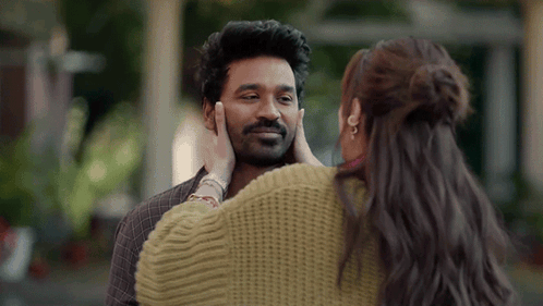 A Woman Is Touching A Man 'S Face In A Close Up . GIF
