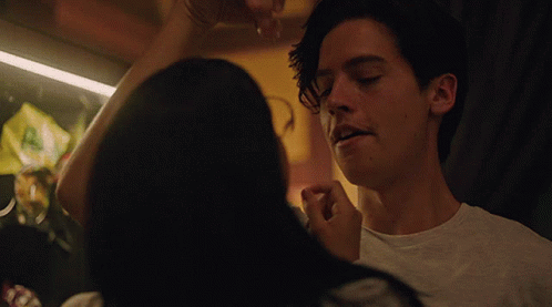 a woman is touching a man 's face in a close up