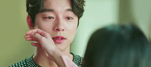 A Woman Is Touching A Man 'S Face With Her Hand While He Is Crying . GIF