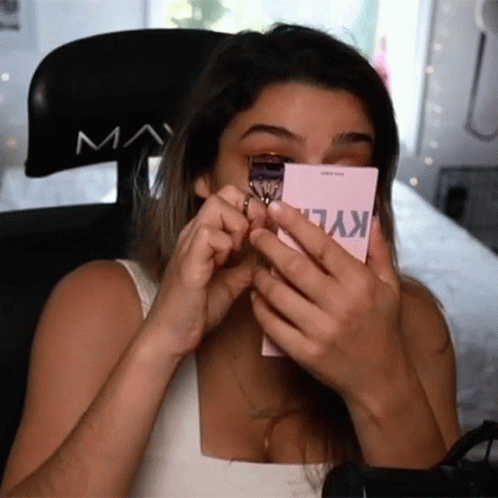 A Woman Is Using A Kylie Eyelash Curler On Her Eye GIF