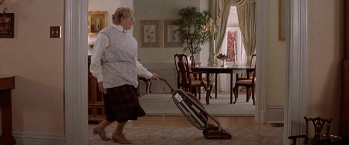 A Woman Is Vacuuming The Floor In A Living Room GIF