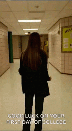 A Woman Is Walking Down A Hallway With The Words " Good Luck On Your First Day Of College " On The Bottom GIF