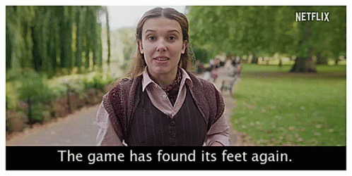 A Woman Is Walking Down A Path In A Park With The Words `` The Game Has Found Its Feet Again '' . GIF