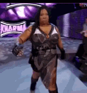 a woman is walking down a runway in a wrestling ring .