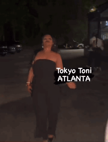 a woman is walking down a street with the words tokyo toni atlanta written on the bottom