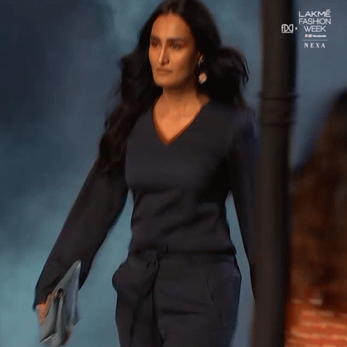 A Woman Is Walking Down The Runway At The Lakme Fashion Week GIF