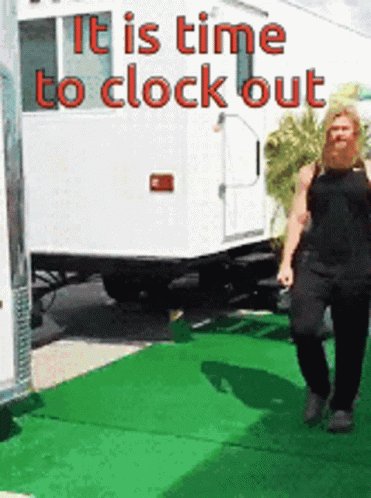 A Woman Is Walking In Front Of A Trailer That Says " It Is Time To Clock Out " GIF