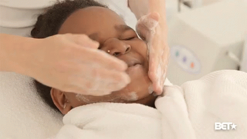 A Woman Is Washing A Child 'S Face And The Bet Logo Is Visible GIF