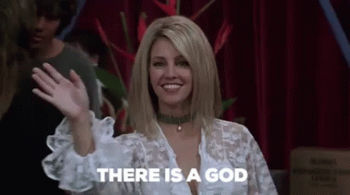 A Woman Is Waving Her Hand And Smiling While Standing In Front Of A Red Curtain . GIF