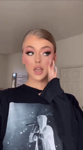 A Woman Is Wearing A Black Sweatshirt With A Picture Of A Person On It GIF