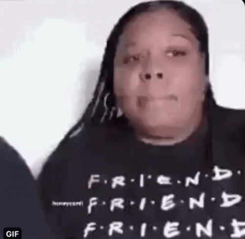 A Woman Is Wearing A Black T-Shirt With The Words `` Friends '' On It . GIF
