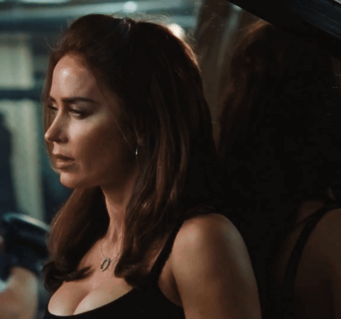 A Woman Is Wearing A Black Tank Top And A Necklace With The Number 0 On It GIF