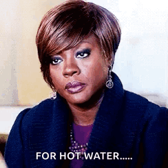 A Woman Is Wearing A Blue Coat And Earrings And Says `` For Hot Water '' . GIF