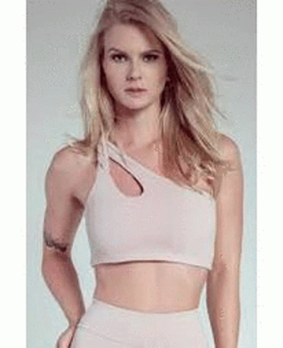 A Woman Is Wearing A Crop Top With A Cut Out On The Side . GIF