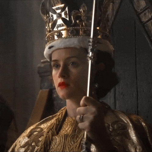 A Woman Is Wearing A Crown And Holding A Scepter GIF