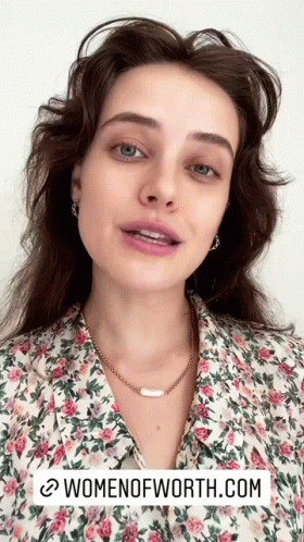 a woman is wearing a floral shirt and a necklace with the website womenofworth.com written below her
