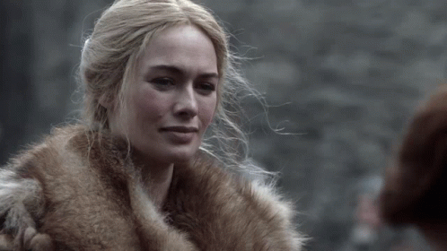 A Woman Is Wearing A Fur Coat And Looking At Something GIF