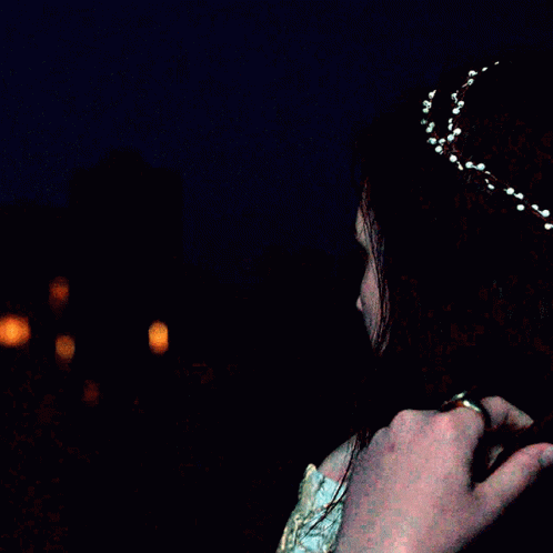 A Woman Is Wearing A Headband With White Beads On It GIF