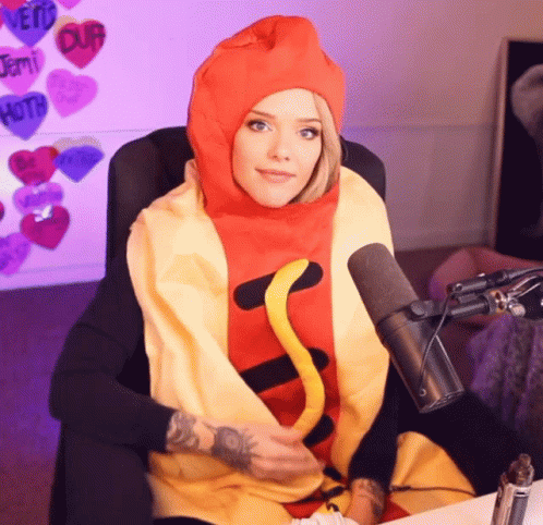 A Woman Is Wearing A Hot Dog Costume And Sitting In Front Of A Microphone GIF