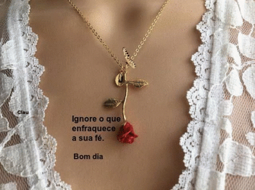A Woman Is Wearing A Necklace With A Red Rose Pendant GIF