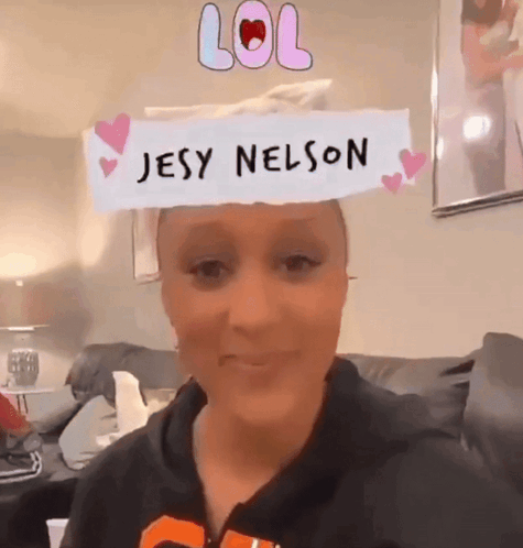 A Woman Is Wearing A Paper That Says Jesy Nelson GIF