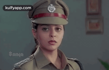 A Woman Is Wearing A Police Uniform And Hat . GIF