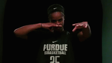 A Woman Is Wearing A Purdue Basketball Shirt And Covering Her Mouth With Her Hands . GIF