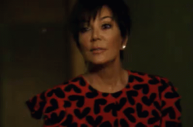 A Woman Is Wearing A Red And Black Dress With Hearts On It . GIF