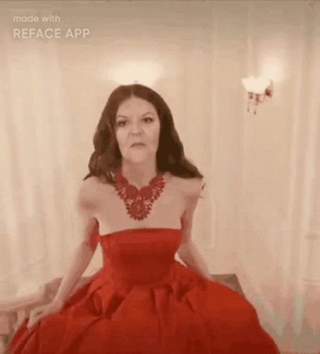 A Woman Is Wearing A Red Dress And A Red Necklace GIF