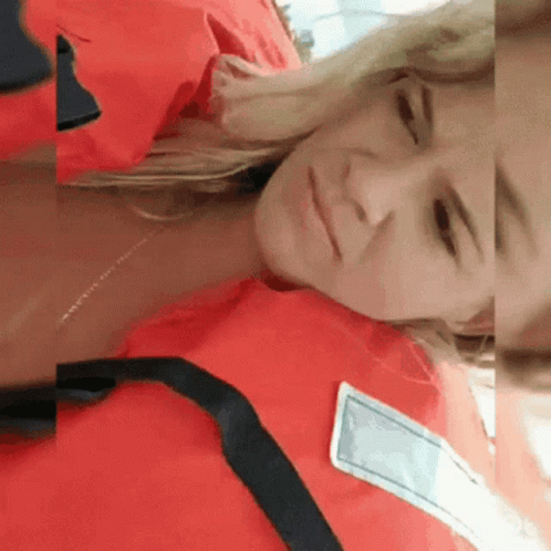 A Woman Is Wearing A Red Life Jacket And Laying Down GIF