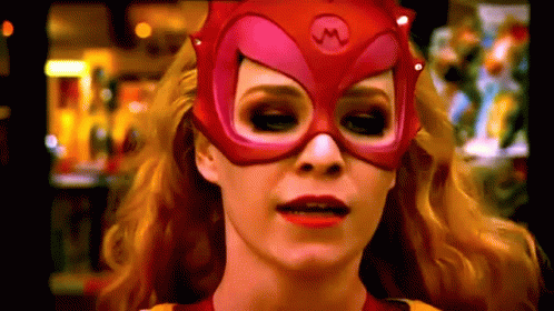 A Woman Is Wearing A Red Mask With A M On It GIF