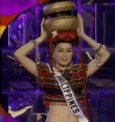 A Woman Is Wearing A Sash That Says Philippines And Is Holding A Bowl On Her Head . GIF