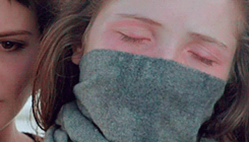 A Woman Is Wearing A Scarf Around Her Neck . GIF