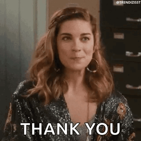A Woman Is Wearing A Sequined Jacket And Earrings And Saying Thank You . GIF