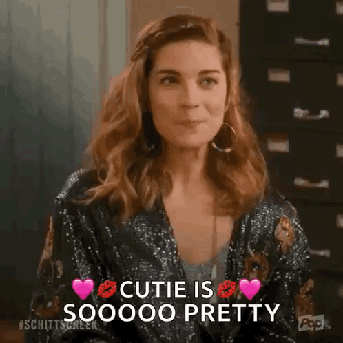 Woman In Sequined Jacket And Earrings Says Cutie Is Pretty GIF
