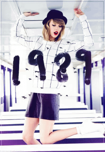 A Woman Is Wearing A Sweater That Says 1989 GIF