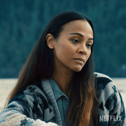 A Woman Is Wearing A Sweater With A Netflix Logo On It GIF