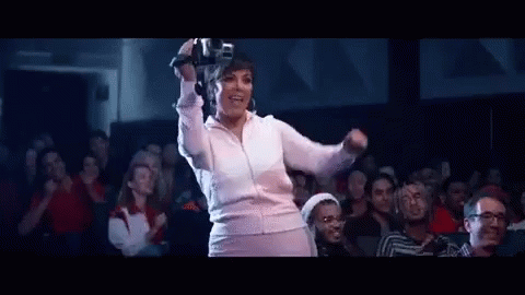 A Woman Is Wearing A Virtual Reality Headset While Dancing In Front Of A Crowd . GIF
