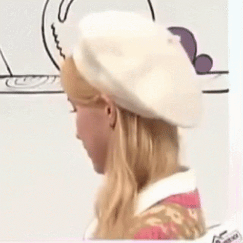 A Woman Is Wearing A White Beret And A Pink Dress . GIF