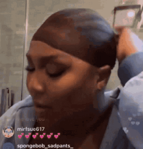 A Woman Is Wearing A Wig And Taking A Picture Of Herself In A Mirror . GIF