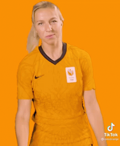 A Woman Is Wearing A Yellow Shirt And Shorts With A Sticker That Says Tiktok GIF