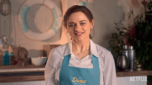 A Woman Is Wearing An Apron That Says Dunes On It GIF