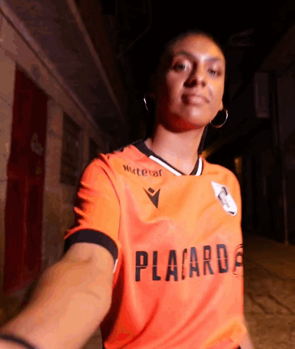 A Woman Is Wearing An Orange Shirt That Says Placard GIF