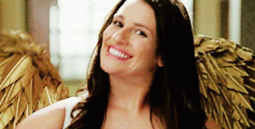 A Woman Is Wearing Angel Wings And Smiling For The Camera GIF