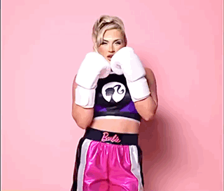 A Woman Is Wearing Boxing Gloves And Shorts That Say Barbie On Them GIF