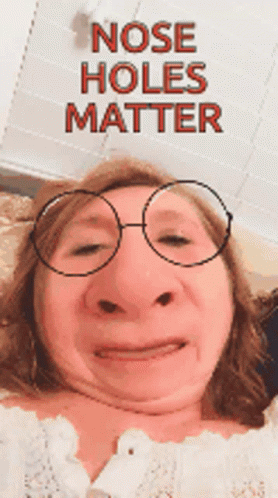A Woman Is Wearing Glasses And Making A Funny Face With The Words Nose Holes Matter Behind Her GIF