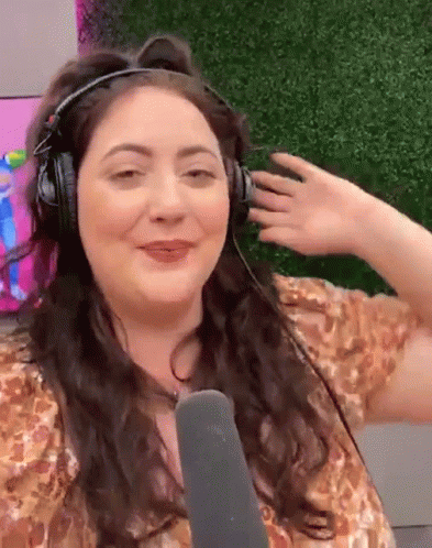 A Woman Is Wearing Headphones And A Microphone And Making A Funny Face GIF