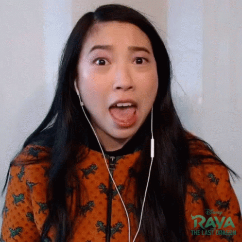 A Woman Is Wearing Headphones And Making A Funny Face While Listening To Music . GIF