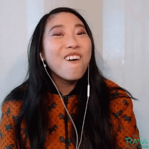 A Woman Is Wearing Headphones And Making A Funny Face While Listening To Music . GIF